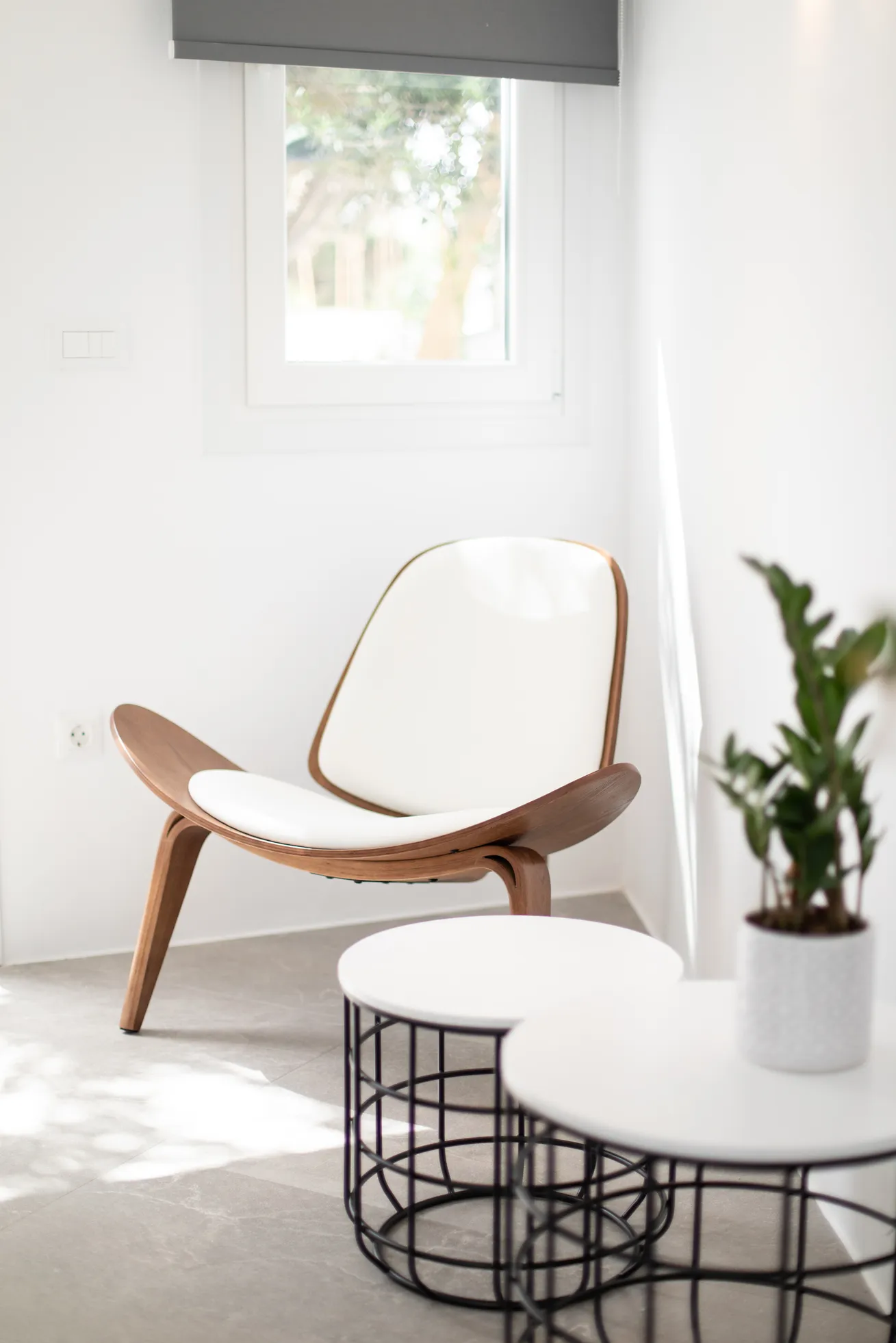 Wooden shell chair and side table by the window